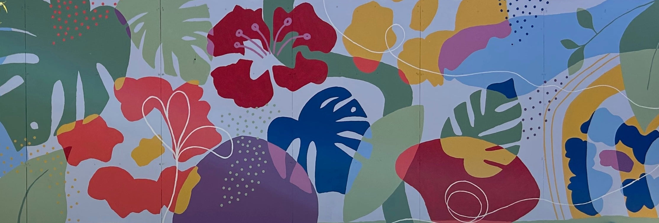 Colorful mural of abstract flowers and leaves on a wall.